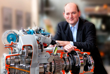 Martin Ritschel leaning against the showcase gearbox of an all-wheel drive small truck